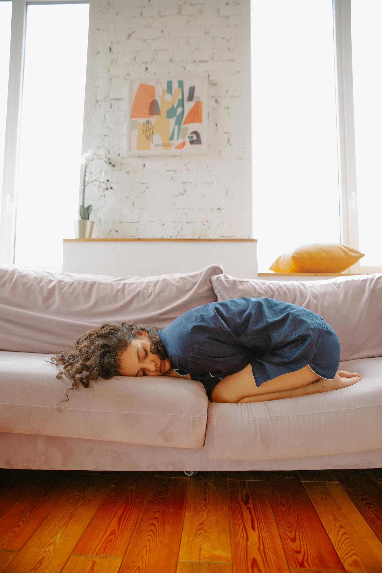 woman with stomach pain on sofa